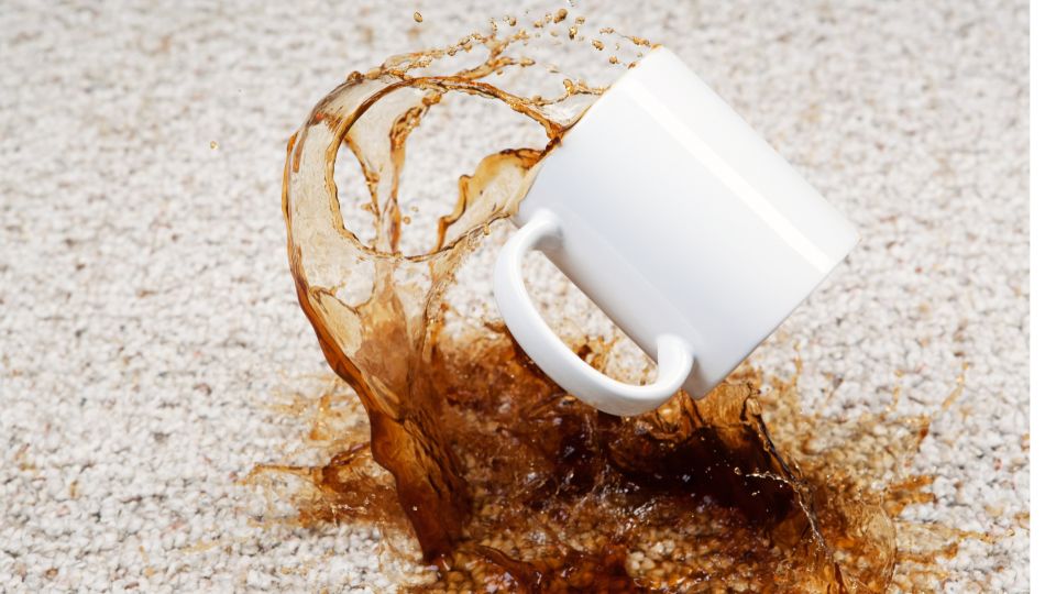 Close-up of a carpet featuring a noticeable coffee stain, highlighting the difficulty of removing common stains from carpets