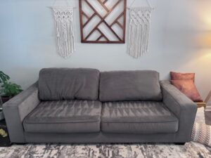 Spotless and freshly cleaned sofa in a cozy living room, showcasing vibrant fabric and immaculate upholstery, highlighting the quality of professional carpet and upholstery cleaning services.