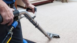 Carpet cleaning technician using professional equipment to deep clean residential carpet, removing dirt and stains for a fresh, revitalized look.